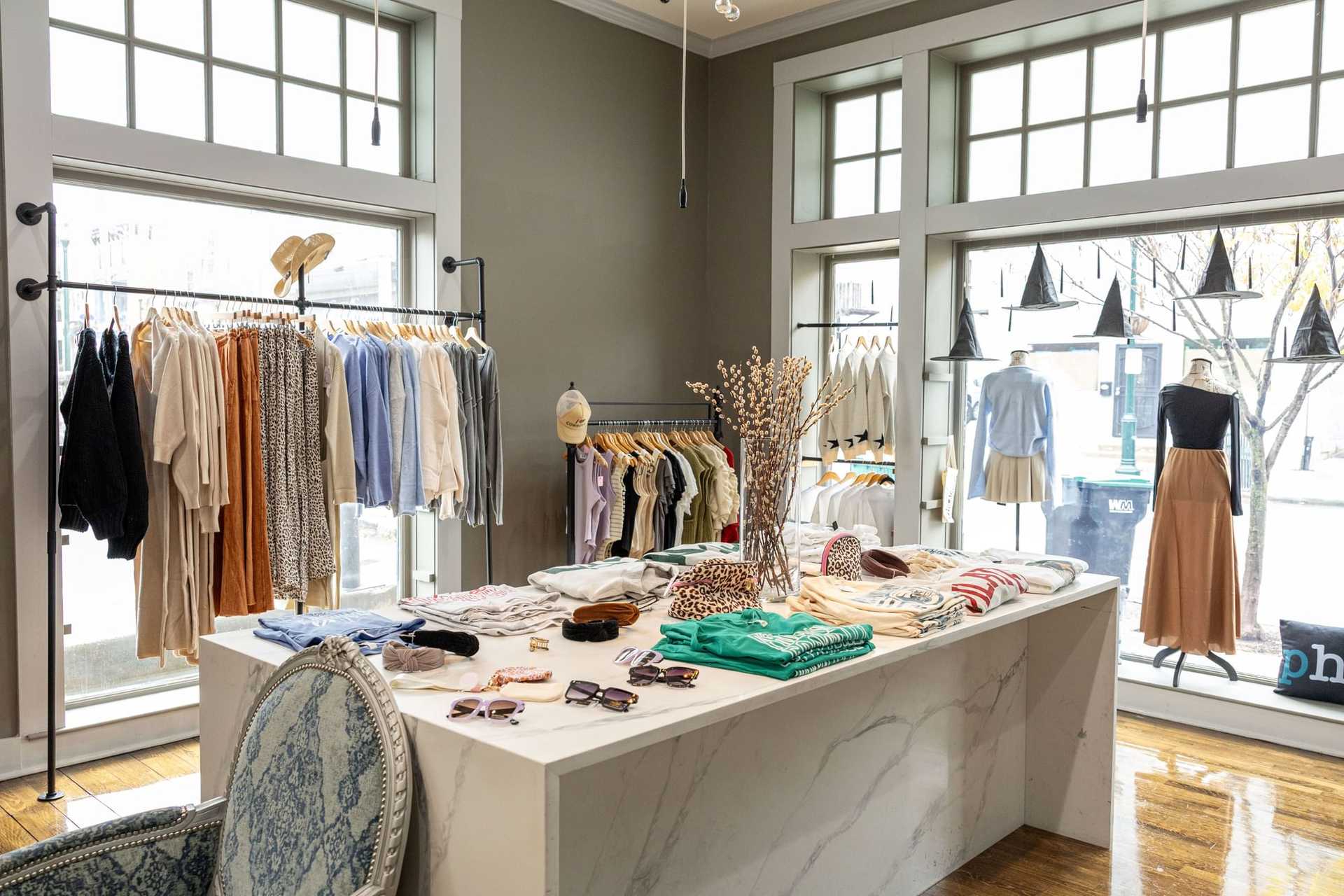 Clothing boutique with stylish outfits, accessories, and modern decor.